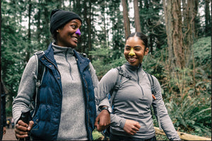 Image of two outdoors persons wearing colorful Nöz sunscreen